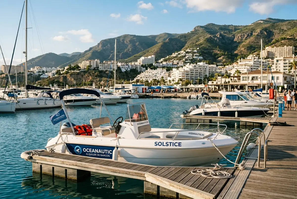 Lancha de alquiler de la base Oceanautic amarrada en un muelle cerca de Benalmádena con la Costa del Sol al fondo, oceanautic alquiler de barcos en málaga