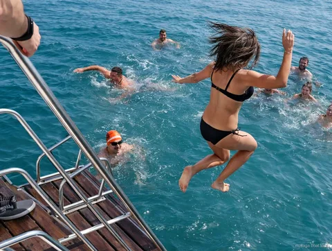 Passagers sautant de la poupe dans la mer lors d'un arrêt baignade d'une balade en bateau à Malaga