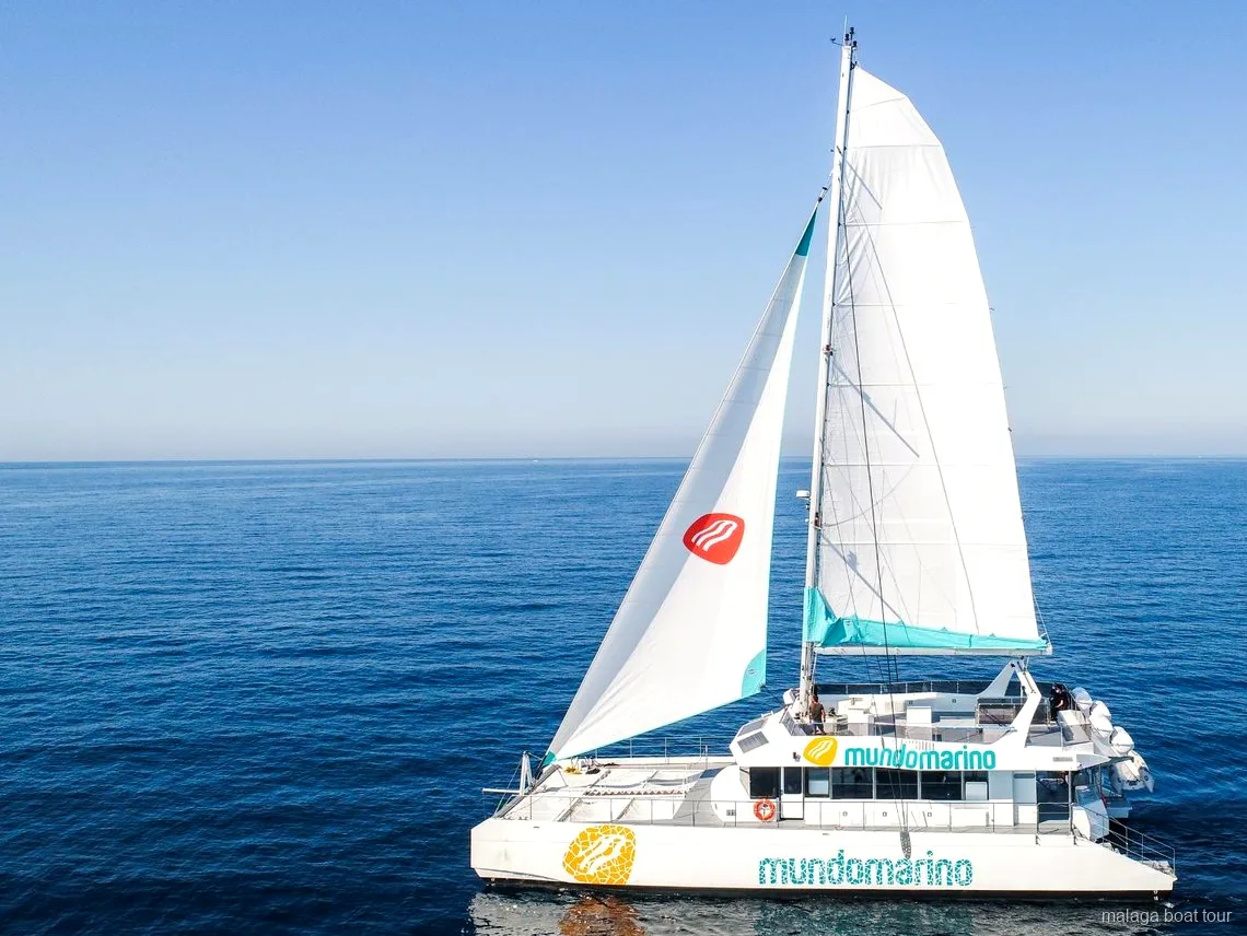 Catamarà de vela amb veles blanques en mar obert i tranquil en una excursió en vaixell a Màlaga