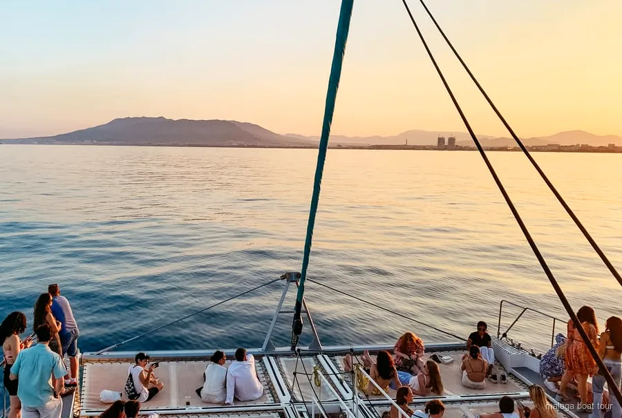 Catamarã a navegar na baía de Málaga ao pôr do sol durante o catamarã ao pôr do sol em Málaga