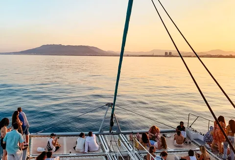 Catamarà navegant la badia de Màlaga a la posta de sol durant el catamarà a la posta de sol a Màlaga