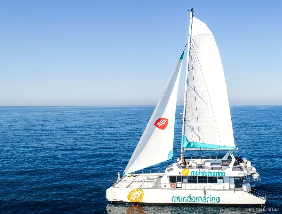 Catamaran à voiles blanches en pleine mer calme lors d'une balade en bateau à Malaga