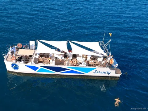 Luchtfoto van de catamaran Serenity met witte zonnezeilen tijdens een boottocht in Malaga