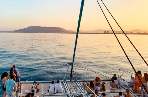 Catamaran naviguant la baie de Malaga au coucher du soleil pendant la croisière coucher de soleil en catamaran à Malaga