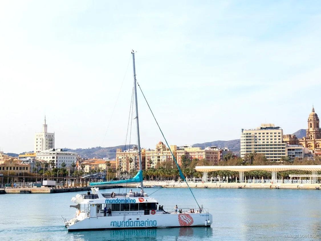 Catamaran Mundomarino voor de waterkant en kathedraal van Malaga tijdens een boottocht