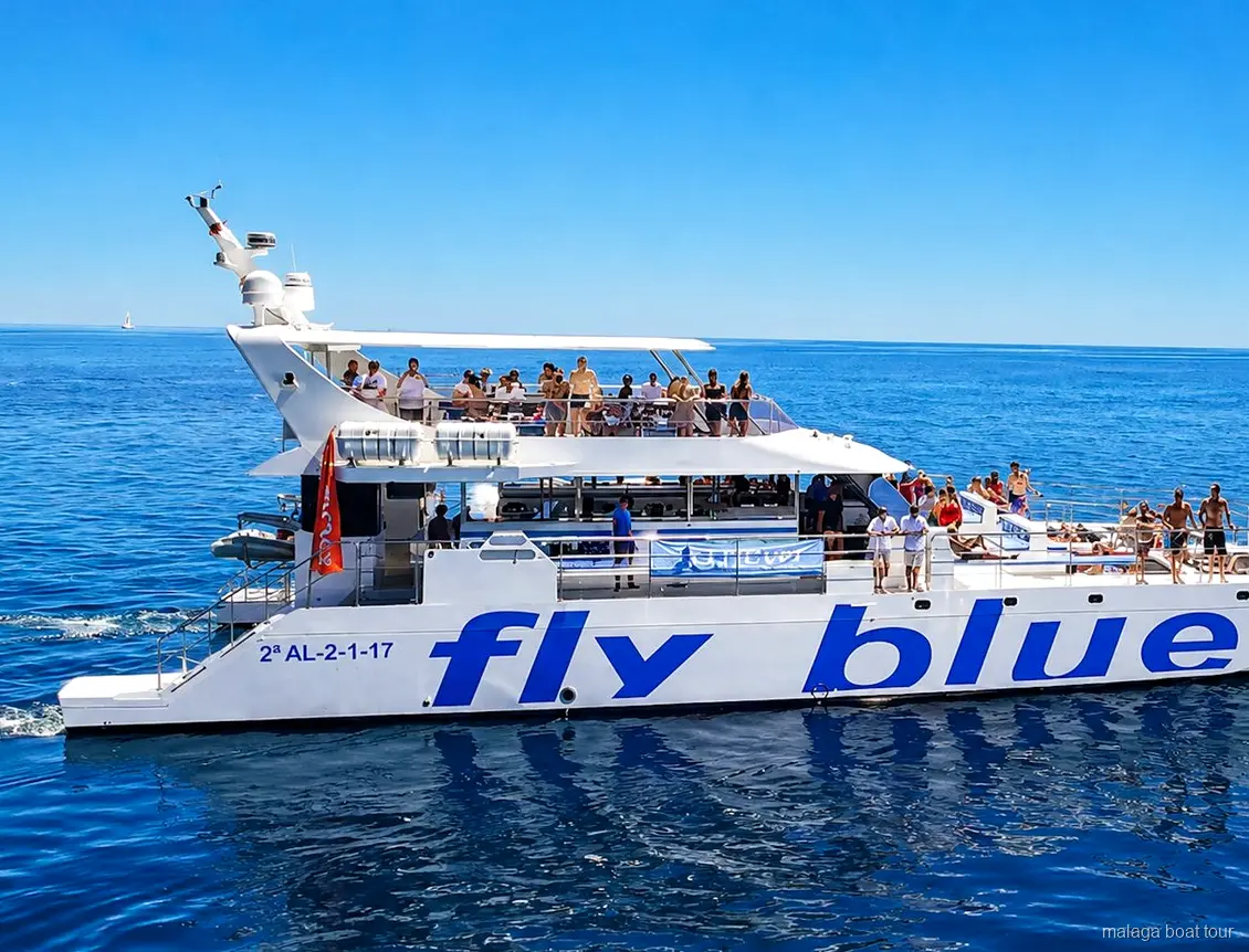 Catamaran met twee dekken en passagiers aan boord onder een blauwe lucht tijdens een malaga boat tour