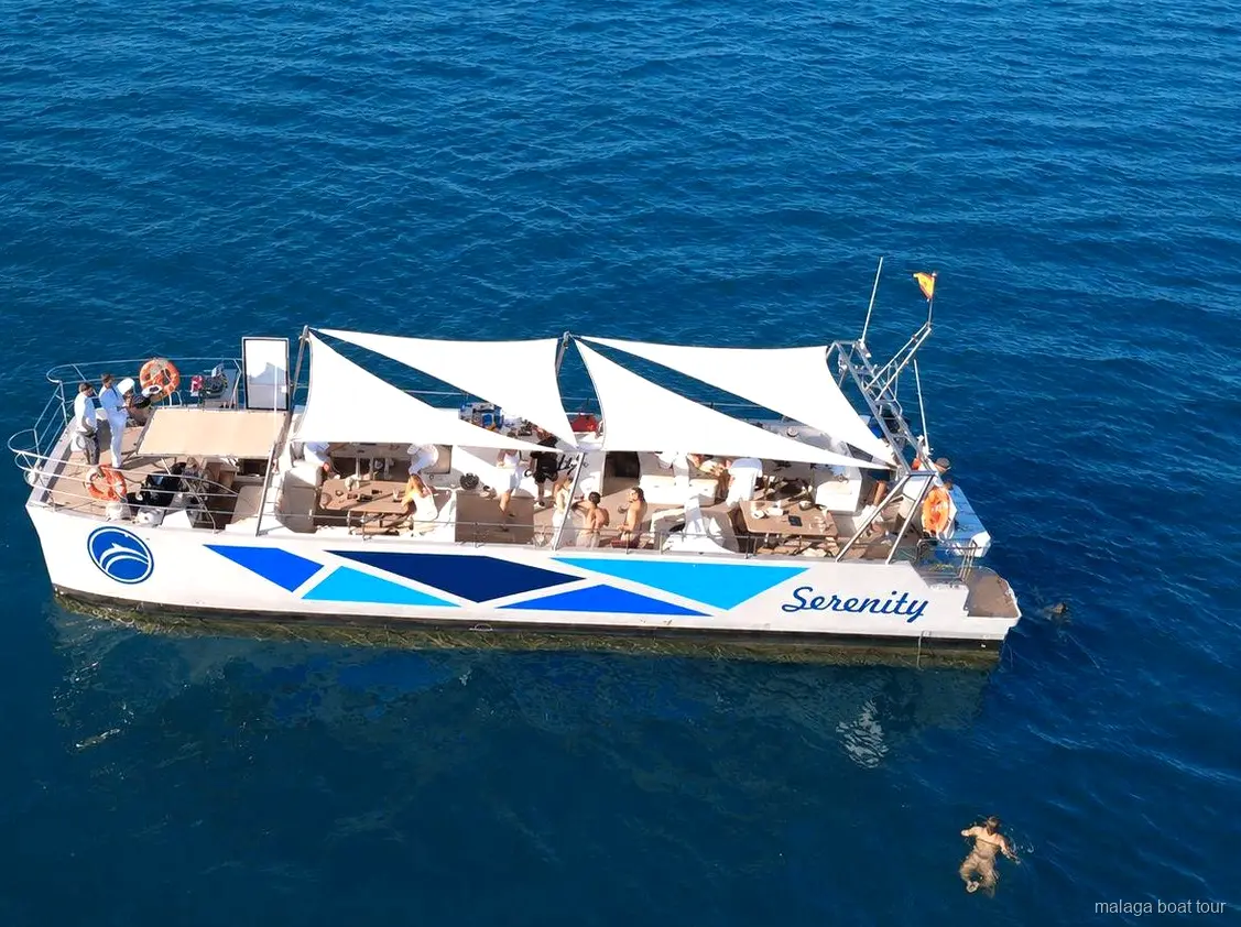 Luftaufnahme des Katamarans Serenity mit weißen Sonnensegeln auf einer Bootstour in Malaga
