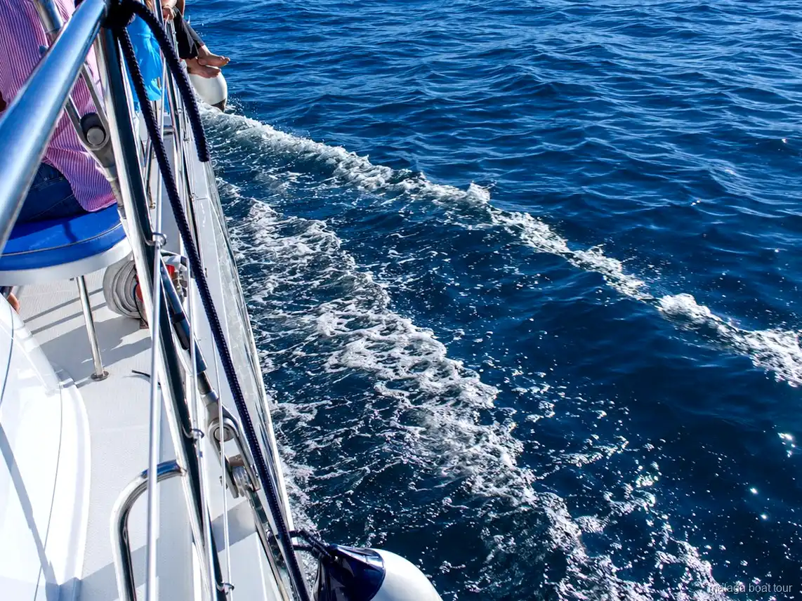 Weiße Gischt am Rumpf eines Katamarans auf tiefblauem Wasser bei einer Malaga Boat Tour