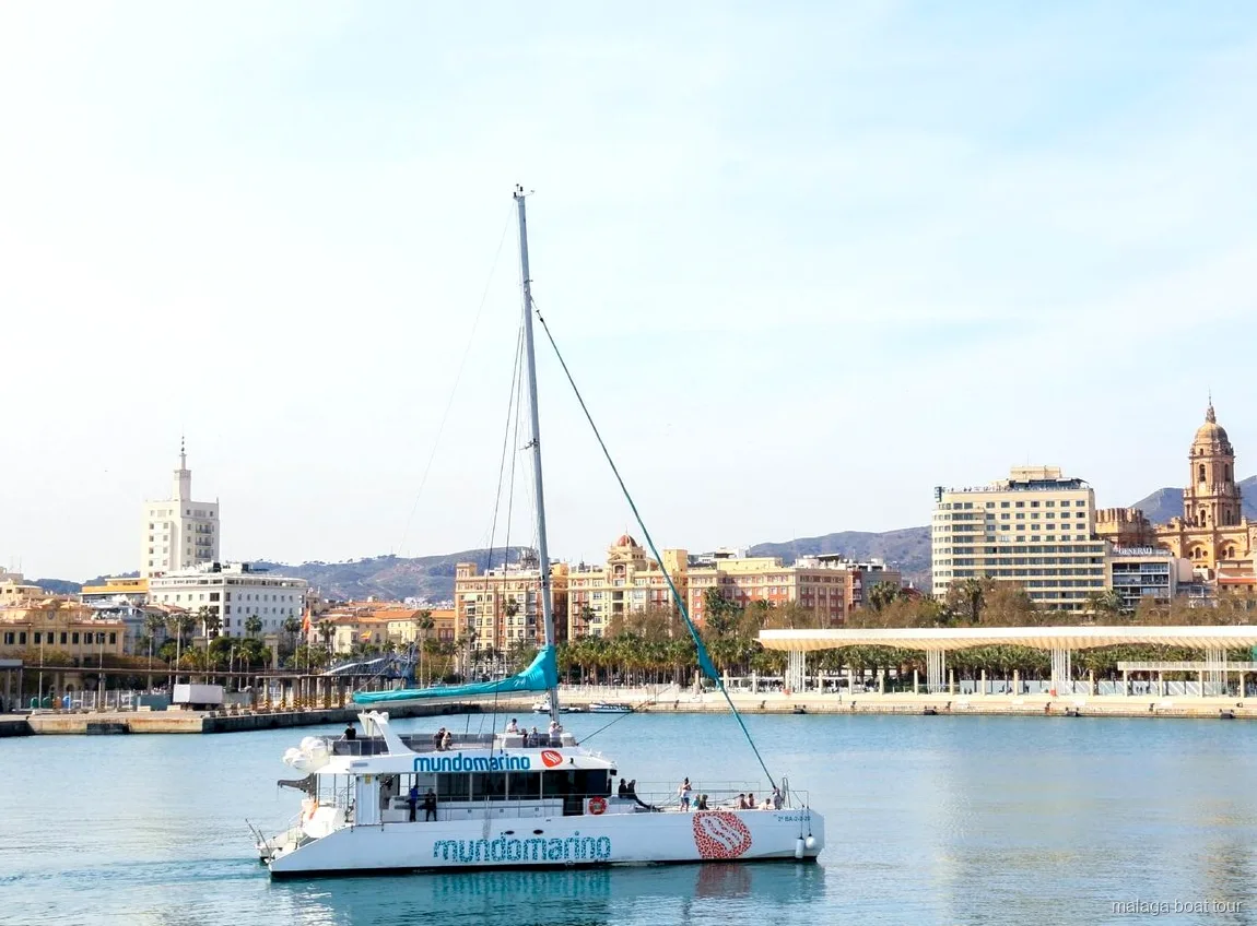 Mundomarino catamaran passing the Malaga waterfront and cathedral on a boat tour