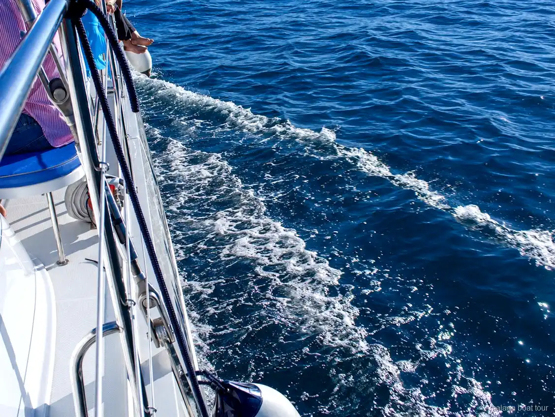 Estela de espuma junto al casco de un catamarán sobre agua azul en un malaga boat tour